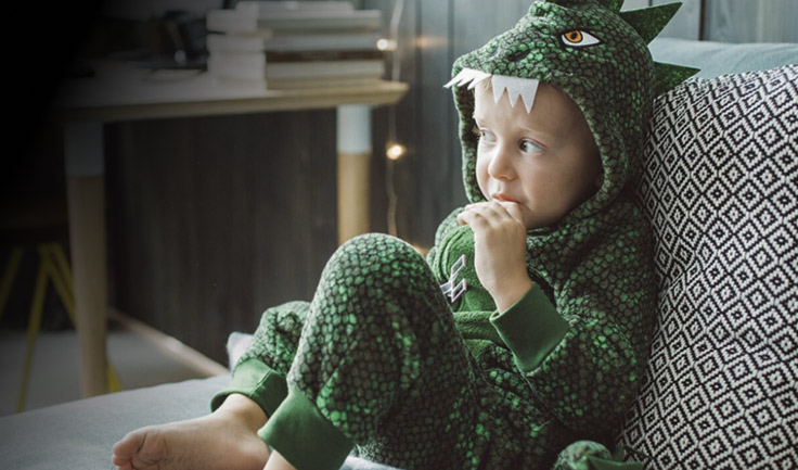 Young kid in Dinosaur Pajamas sitting on Couch